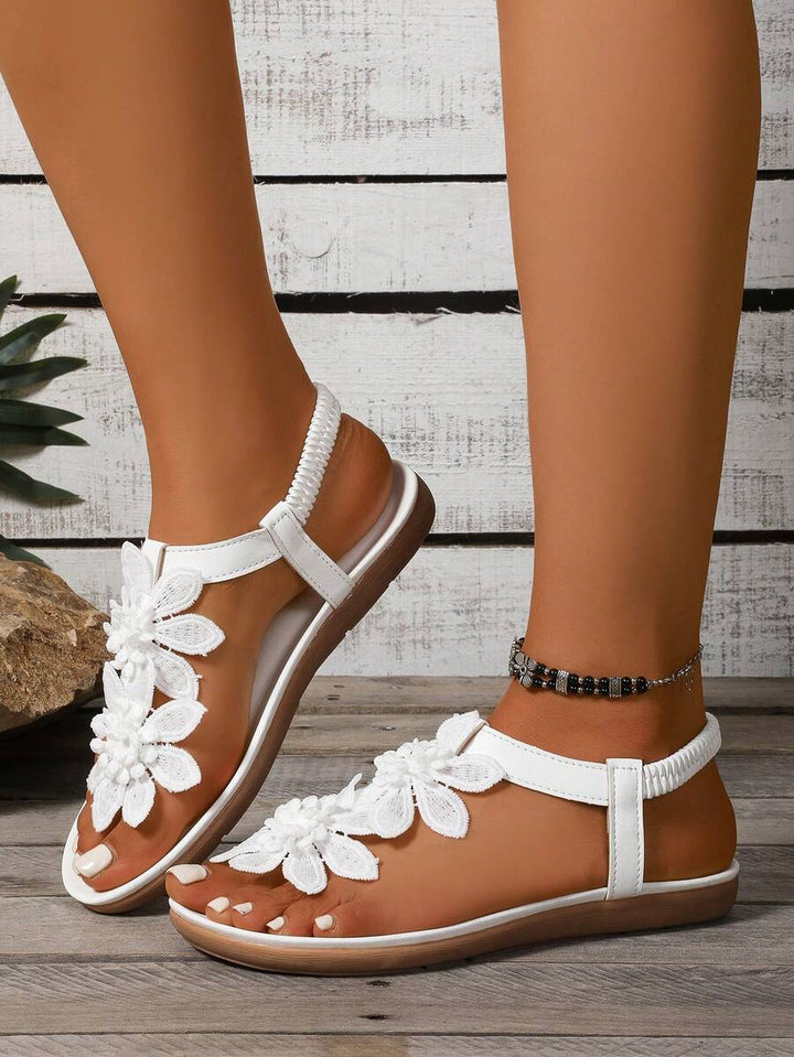 Damen Sandalen mit Blumenapplikation in schräger Seitenansicht