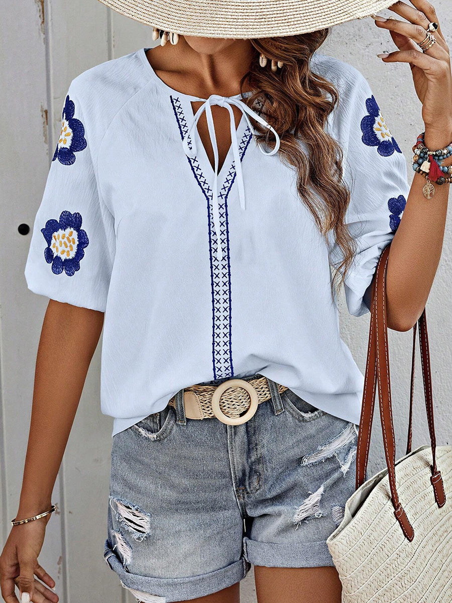 Damenbluse mit femininer Stickerei und Kontrastbesatz im Detail