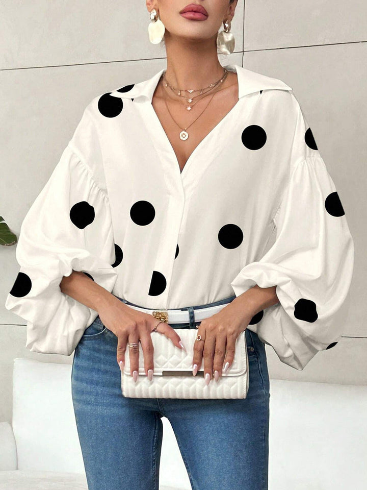 Detailaufnahme von Plissee, Reverskragen und Polka-Dot-Muster der Bluse