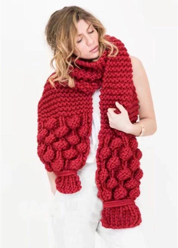 Damen trägt einen modischen Strickschal mit Zopfmuster