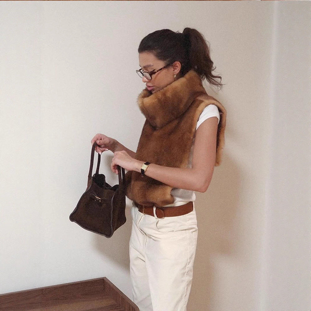 Damen trägt einen wärmenden Kunstfell-Wickelschal im Herbst