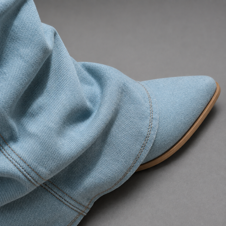 Seitliche Ansicht kniehoher Damenstiefel aus Denim mit Blockabsatz