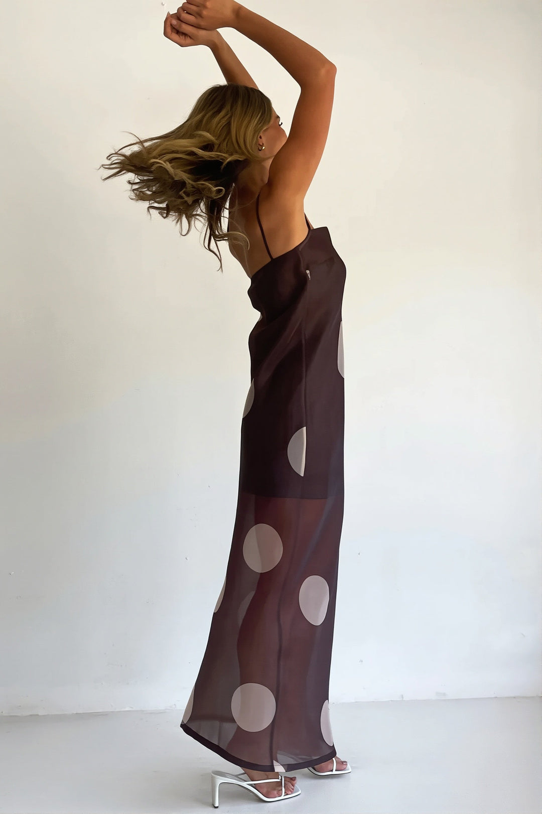 Damen in figurbetontem Maxikleid mit Punkten und schulterfreiem Ausschnitt