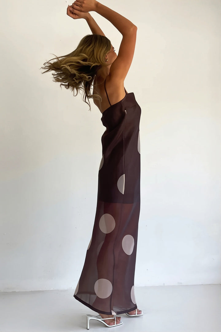 Damen in figurbetontem Maxikleid mit Punkten und schulterfreiem Ausschnitt
