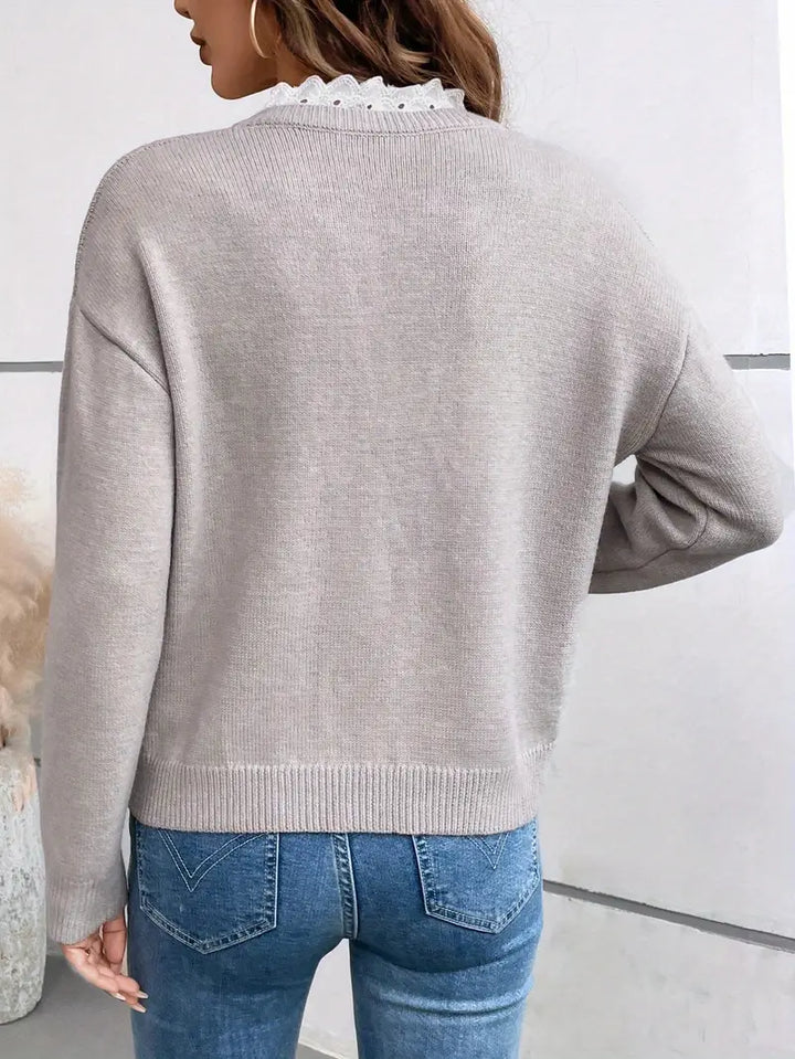 Detailansicht des V-Ausschnitts mit feiner Spitze am Damenpullover