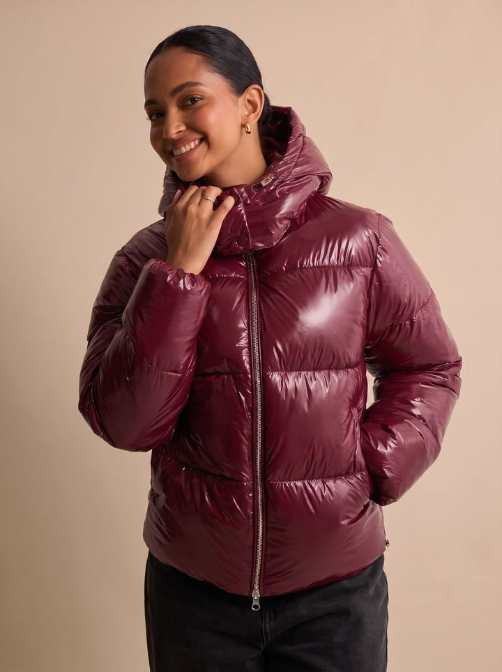 Seitliche Ansicht einer glänzenden Damen-Steppjacke mit Kapuze und Reißverschluss